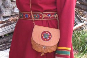 Dame med kofte, belte og veske.