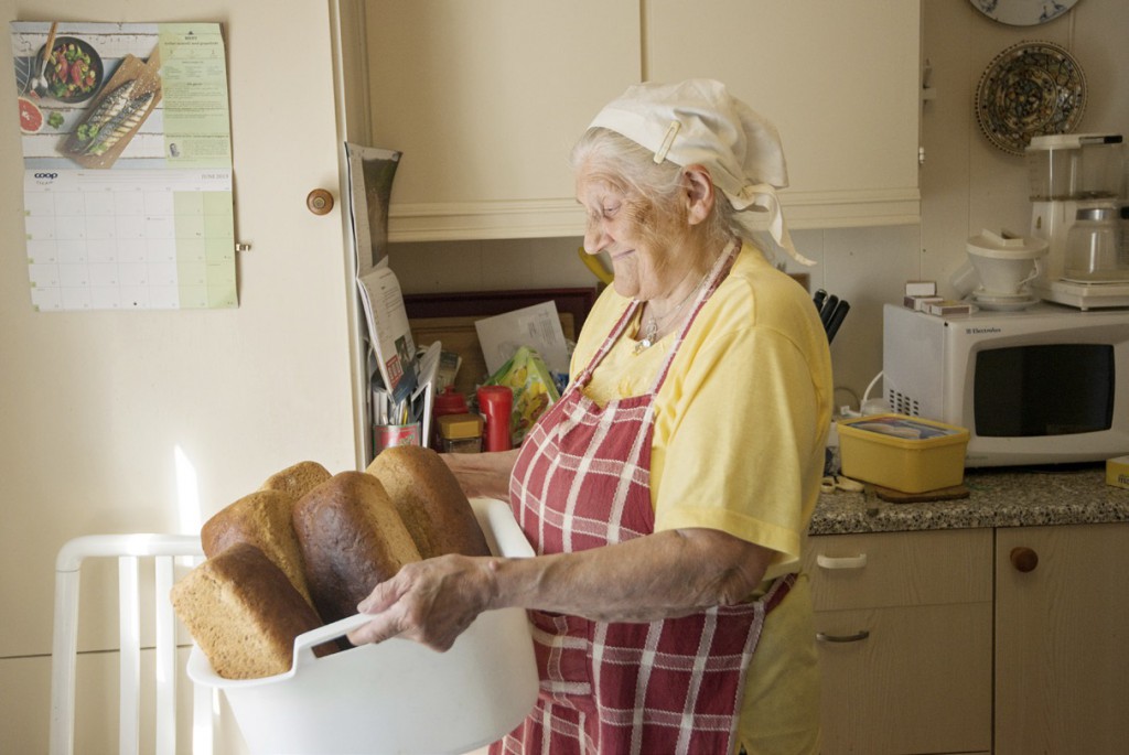 Oliva Nilsen bærer på balje med nybakte brød.