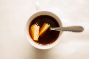 Kaffeost. Kaffekopp med os og skje.