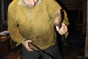 hans7 Hans bearbeider knivbladet på ambolten.